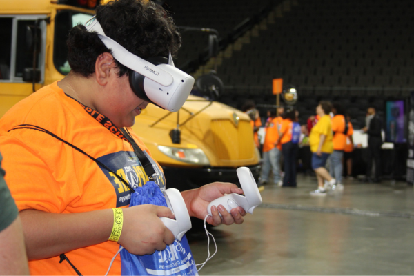  A boy in an orange shirt tries out a VR headset